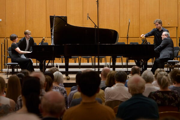 Pianistin und Pianist an zwei Flügeln