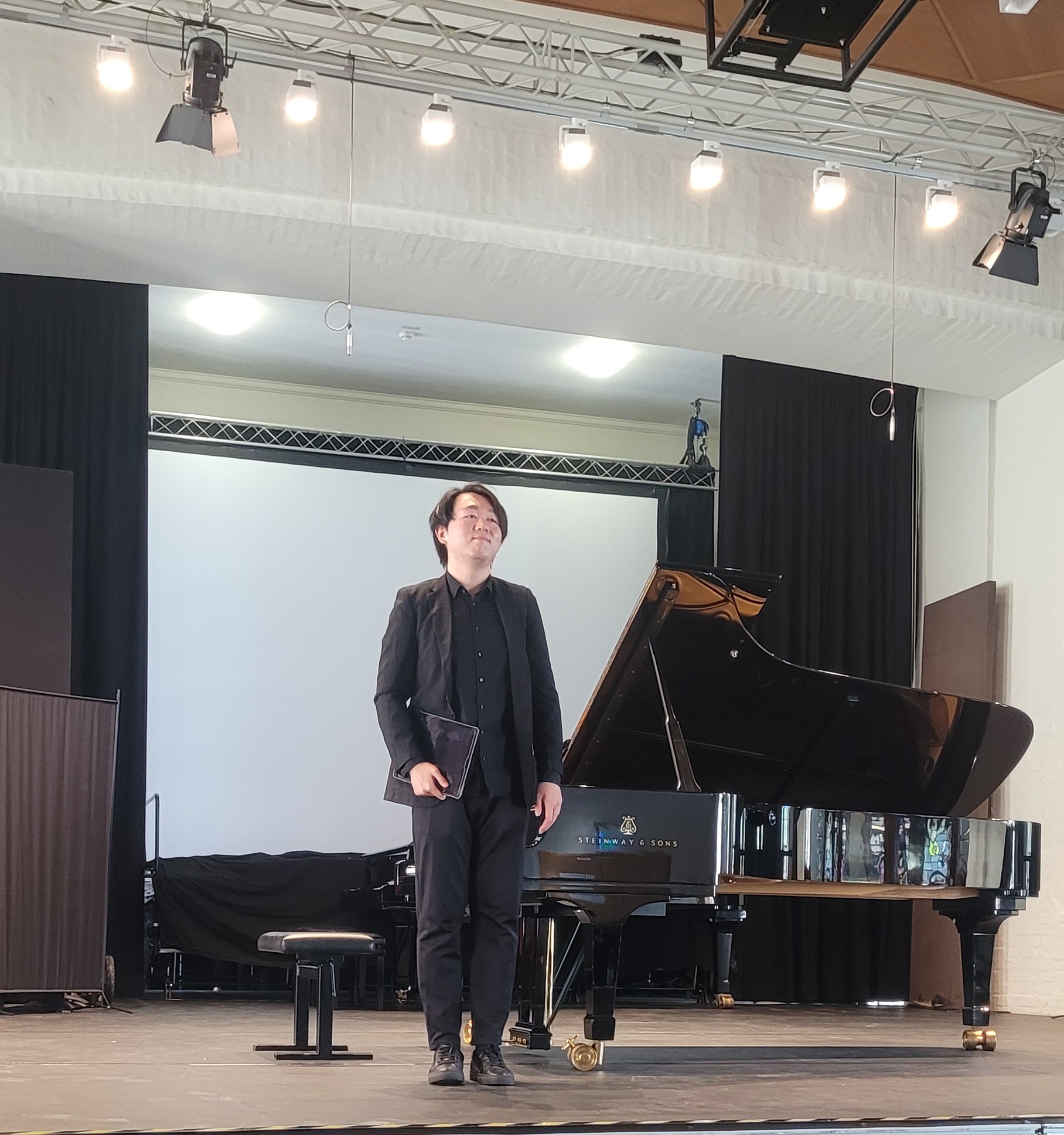 Pianist auf der Bühne, vor dem Flügel stehend