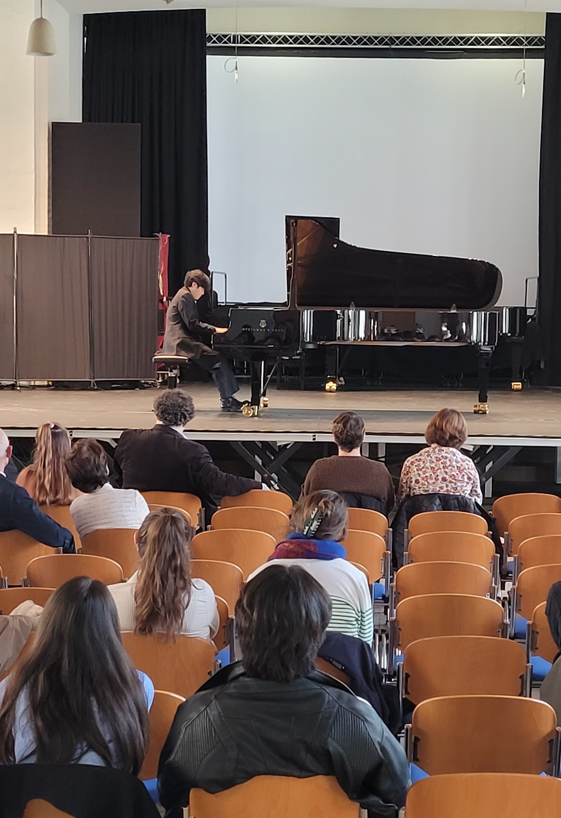 Pianist am Flügel, davor das Publikum